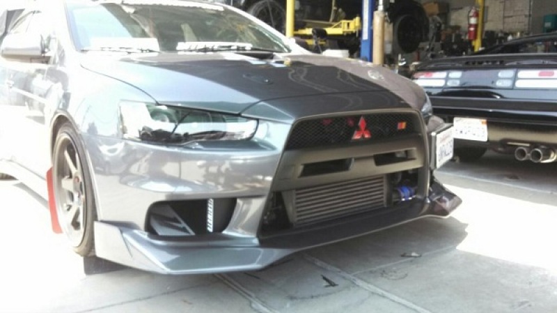 Mishimoto Evolution X oil cooler kit installed behind passenger side foglight