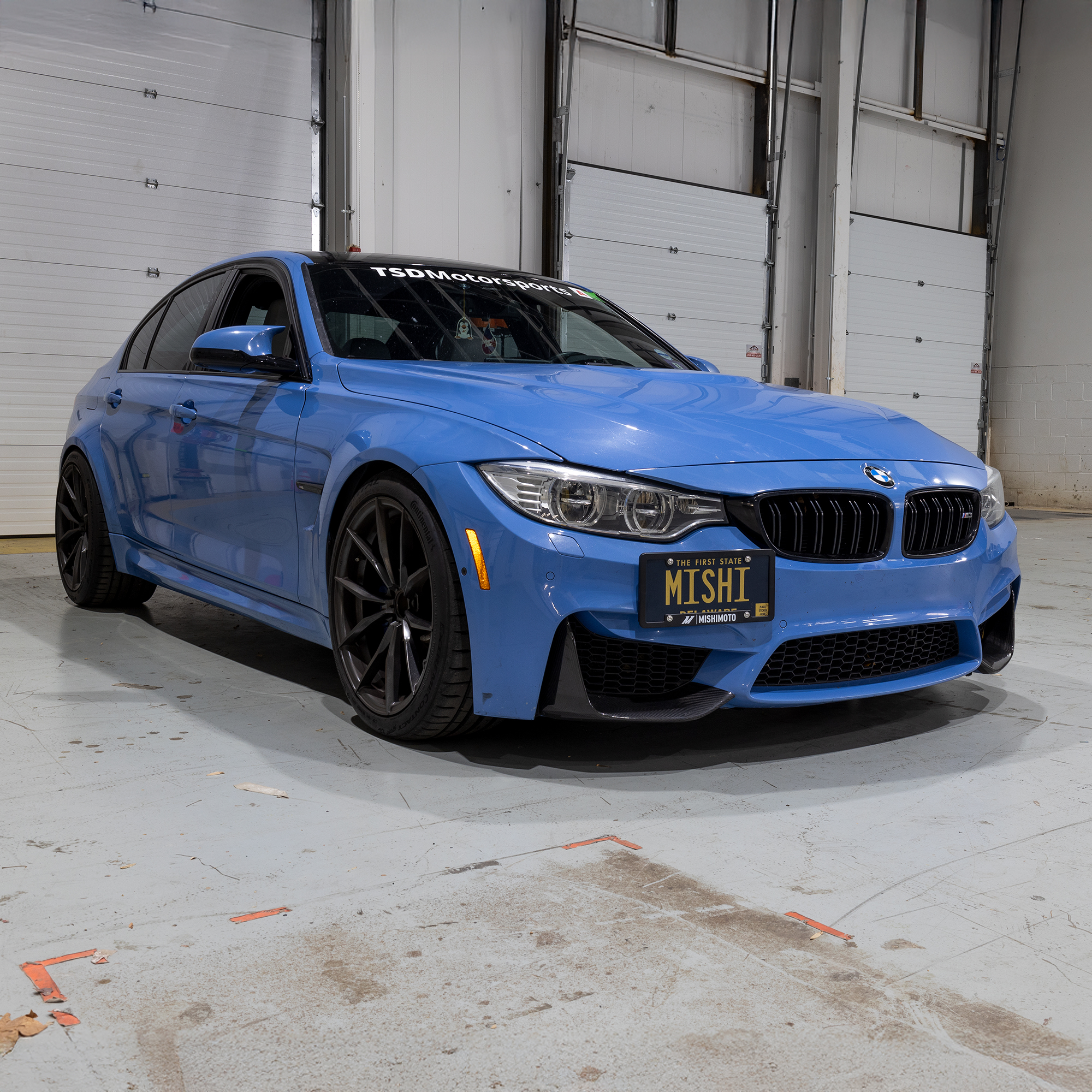 6061 aluminum Mishimoto license plate relocation kit mounted to a BMW M4 front tow hook