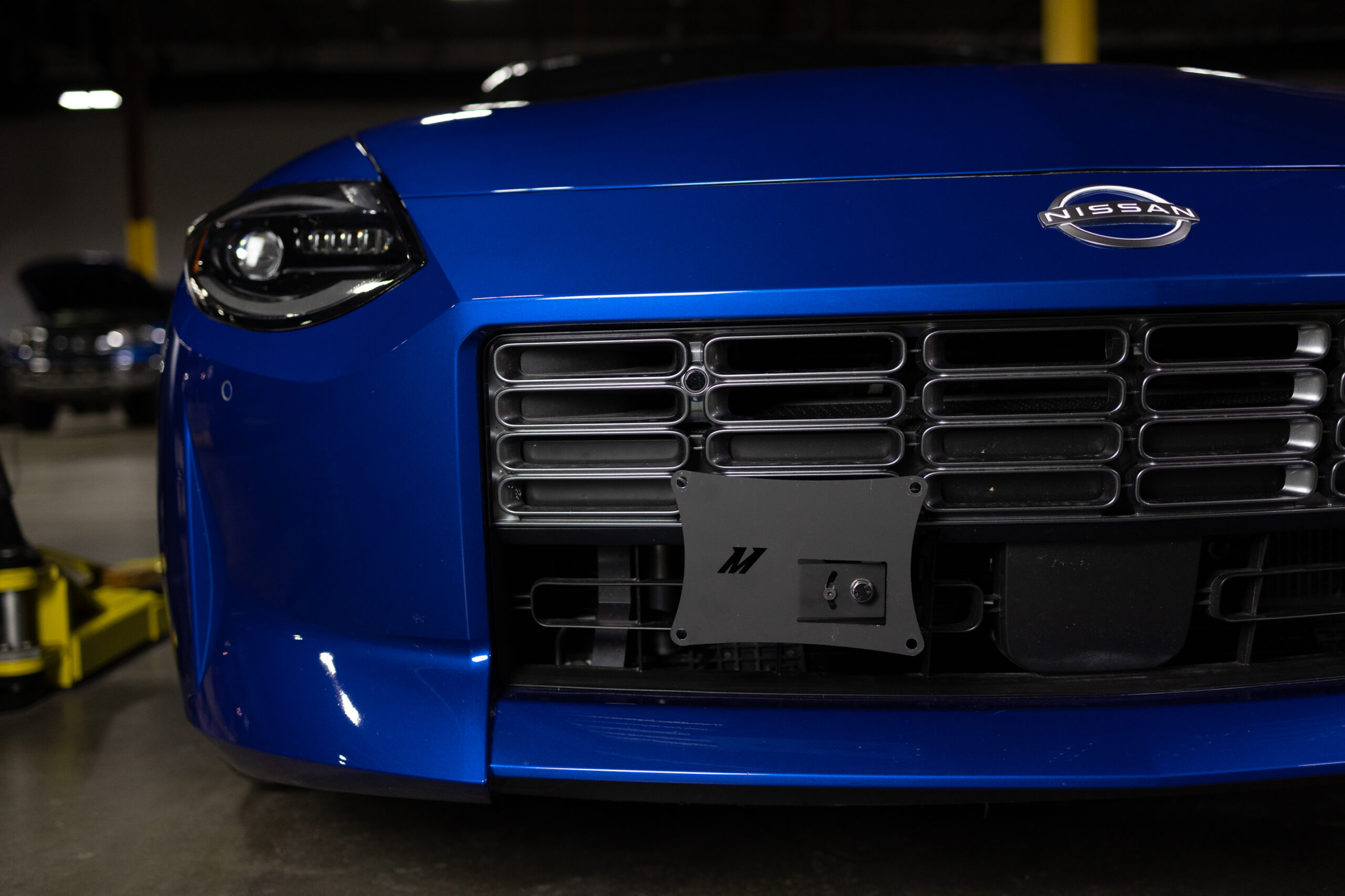 Nissan Z front bumper with relocated license plate showing open grille airflow path